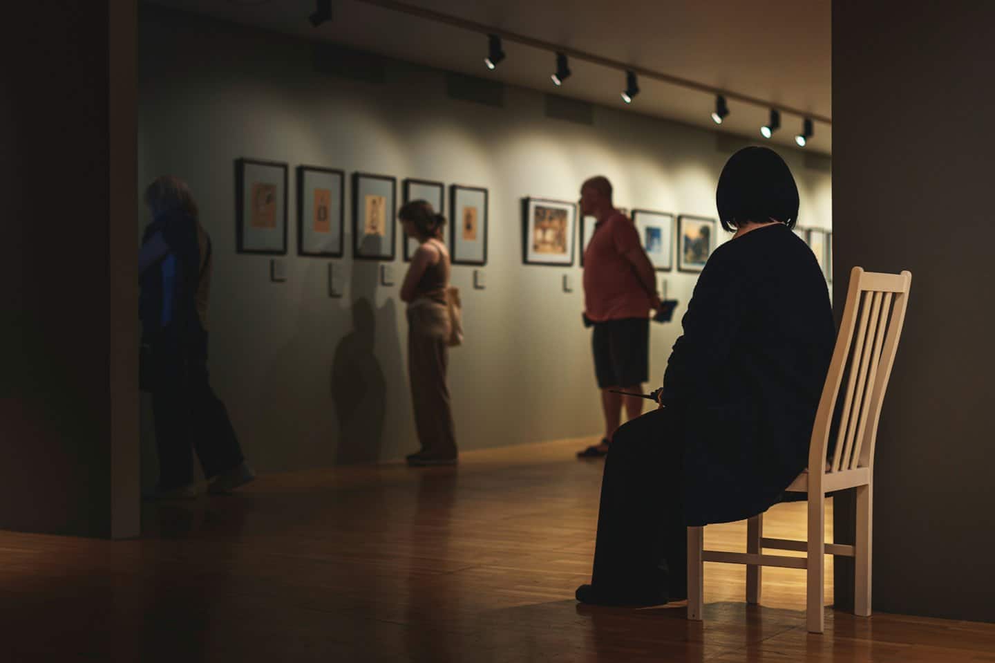 Persone che ammirano opere d'arte in una galleria moderna.